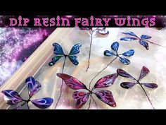 some purple and blue butterflies sitting on top of a glass table with the words dip resin fairy wings