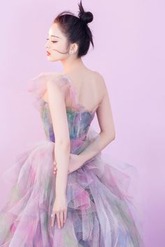 a woman in a colorful dress poses for the camera