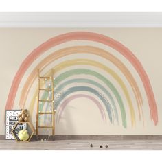 a rainbow painted on the wall with a ladder next to it and a teddy bear