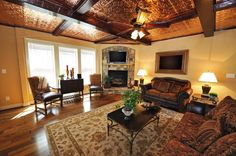 a living room filled with furniture and a flat screen tv mounted on the wall above a fire place