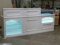 a white cabinet with doors and drawers in a room filled with workbench materials