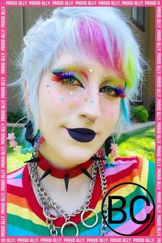 a woman with colorful makeup and piercings on her face is posing for the camera