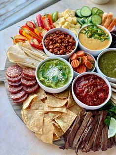 a platter filled with different kinds of food and dips on top of it