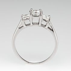 This beautiful three-stone engagement ring is accented with three (3) square modified brilliant cut diamonds set into four-prong heads. The ring measures 5.5mm at the top, rises 7.2mm above the finger, tapering to 1.5mm wide and 0.7mm thick at the base of the shank. This ring is currently a size 6.75. Three Stone Cubic Zirconia Diamond Ring Princess Cut, Princess Cut Three Stone Cubic Zirconia Diamond Ring, Three Stone Princess Cut Cubic Zirconia Ring, Fine Jewelry Three Stone Princess Cut Diamond Ring, Timeless Three Stone Radiant Cut Ring, Timeless Three Stone Rings With Radiant Cut, Classic Three Stone Princess Cut Diamond Ring, Classic Three Stone Princess Cut Rings, Princess Cut Three Stone Diamond Promise Ring