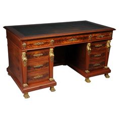 an antique wooden desk with two drawers and brass pulls on the top, against a white background