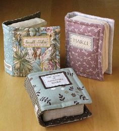 three small books sitting on top of a wooden table