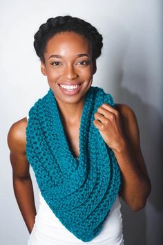 a woman wearing a blue crocheted scarf