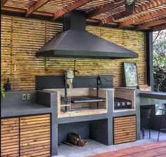 an outdoor kitchen is built into the side of a wooden structure with grill and counter space