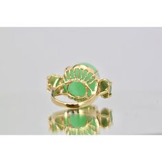 This is part of Chairish’s Fine Jewelry assortment.  18K Bullet Chalcedony and Jade 3 Stone Ring in Yellow Gold  This gorgeous 18K Bullet Chalcedony and Jade 3 Stone Ring in Yellow Gold is unique and you will not see another one. This ring is 19.31 high and deep and 17.67 round.  Furthermore, the Jade stones are approximately 0.75 carats each with a weight of 14.5 grams.  Bullet stones are very rare especially in this size. Do not wait. Luxury Green Oval Gemstones, Luxury Yellow Gold Opal Ring With Gemstone Accents, Luxury Green Rings With Gemstone Accents, Luxury Yellow Gold Opal Ring With Accent Stones, Elegant Green Cabochon Emerald Ring, Elegant Green Emerald Cabochon Ring, Elegant Green Enamel Ring With Polished Finish, Yellow Gold Jade Cabochon Ring, Green Enamel Ring For Formal Occasions