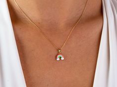 This 14K gold rainbow necklace is a colorful and dainty piece of jewelry that would make a beautiful gift for any occasion. The rainbow pendant is a symbol of friendship and pride, and would be a thoughtful present for a loved one on Christmas, Father's Day, Mother's Day, Valentine's Day, an anniversary, or a birthday. The necklace is a choker style and would sit close to the neck, making it perfect for layering with other necklaces or wearing on its own. It would make a lovely addition to any j Colorful Pendant Jewelry As A Gift, Rainbow Necklace With Adjustable Chain For Gift, Multicolor Pendant Charm Necklace As Gift, Colorful Necklace With Adjustable Chain As Gift, Handmade Rainbow Necklaces For Everyday Wear, Handmade Rainbow Necklaces For Everyday, Handmade Rainbow Necklace For Everyday, Rainbow Pendant Jewelry Gift, Colorful Jewelry With Adjustable Chain As Gift