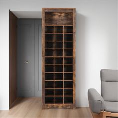 an empty living room with a chair and bookcase in the corner on the floor