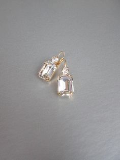 "These beautiful elegant earrings are made with fancy emerald cut and round Swarovski crystals. Available in gold, rose gold and silver finish. Matching necklaces an the bracelet are also available and they are shown in the last two photos. - 1 3/8\" long from the top of the ear wire to the bottom of the earring and 1/2\" wide - Leverback - For the matching bracelet please take a look here: https://www.etsy.com/listing/754440549/swarovski-crystal-bridal-bracelet-gold?ref=shop_home_active_19& Bridal Gold Earrings, Wedding Drop Earrings, Inexpensive Jewelry, Earrings Emerald, Gold Bridal Earrings, Wedding Earrings Drop, Matching Jewelry, Jewelry Lookbook, Earrings In Gold