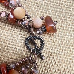 This rustic, beautiful multi-strand bracelet is made from three strands of large aventurine chips, copper/gray faceted rondelles, rust-colored bicones, copper spacers and frosted gold glass rounds. The heart toggle is completed with two beaded dangles. All metals are nickel and lead free. Multi Strand Bracelet, Strand Bracelet, Gold Glass, Rust Color, Beaded Dangles, Amber Glass, Multi Strand, Earrings Set, Earring Set