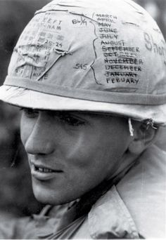 black and white photograph of a man wearing a hat with words written on the side