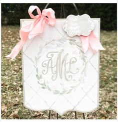 a white sign with a pink bow on it's side and the letter m