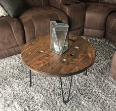 a wooden table sitting on top of a carpeted floor next to a brown couch