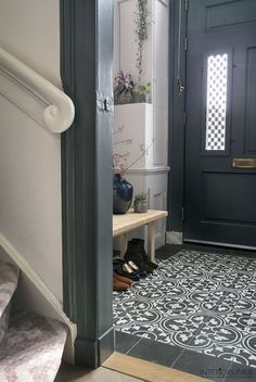 an image of a hallway with black and white tiles on the floor, in front of a door