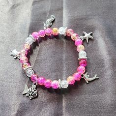 This Super Cute Bracelet Can Double As An Ankle Bracelet As Well. Really Cute By Itself Or If You Stack With Other Pieces. The Beads Are Lamp Work Crackle Glass And The Charms Are Metal. This Was Measured Out To 10 Inches Before I Tied It Off. Should Fit Around 8 To 10 Inch Ankle. Casual Pink Handmade Anklet, Adjustable Bracelet With Lobster Clasp For Vacation, Handmade Charm Bracelet For Beach, Casual Adjustable Beaded Bracelets With Lobster Clasp, Adjustable Colorful Beads Charm Bracelet For Beach, Silver Beaded Stretch Bracelet For The Beach, Adjustable Beaded Crystal Bracelet For Summer, Adjustable Casual Crystal Bracelet For Parties, Pink Crystal Bracelet With Round Beads For Beach