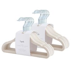 two wooden clothes hangers with white paper attached to each one's sides, on a white background