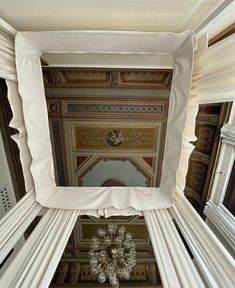 the ceiling is decorated with white columns and chandelier