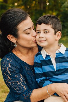 a woman kissing a young boy on the cheek