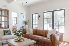 a living room filled with furniture and lots of windows