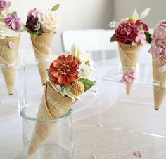 there are ice cream cones with flowers in them