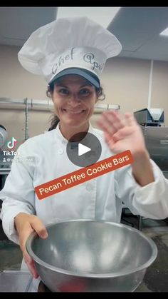 a woman in a chef's hat is holding a metal bowl with food on it