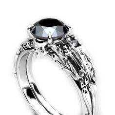 a black diamond engagement ring set with skulls on the sides and an oval center stone