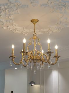 a chandelier hanging from the ceiling in a room with white walls and ceilings