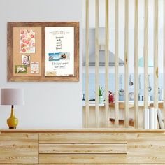 a wooden dresser sitting next to a wall with pictures on it