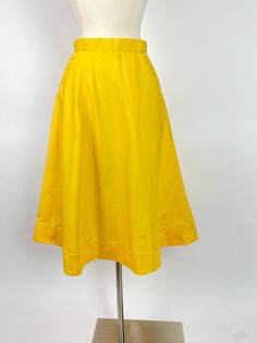 "Late 1970s Yellow A Line Skirt Front slide button closure, see photos A line shape Waist: 24\" Hips: 42\" Length: 28\" Opening: 32\"/33\" Labels/Materials: Feels like a polyester cotton blend or polyester and synthetic blend - Metal slide hook buttons Excellent vintage condition, just one tiny pin dot" Daywear A-line Lined Skirt, Spring A-line Bottoms With Button Closure, Classic A-line Skirt For Summer, Classic A-line Summer Skirt, Summer A-line Skirt With Button Closure, Summer Retro Solid Color Skirt, Retro A-line Cotton Bottoms, Retro Solid Color Skirt For Spring, Retro A-line Fitted Bottoms