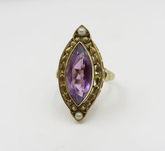 Originally $1,200.00 Circa 1900. Gorgeous Marquis Amethyst ring accented by pearls and beautiful engraving and open work detail in 14KT gold. A very elegant antique cocktail ring. The Bezel set Amethyst measures approximately 18mm x 8mm. The mounting/top of the ring, measures (point to point) approximately 28mm. The width of the mounting is approximately 11mm. The ring is a size 7 3/4 and can be sized. Customer Care: I will help guide you throughout the entire process of your ring selection. I o Antique Yellow Gold Oval Pearl Ring, Antique Oval Yellow Gold Pearl Ring, Antique Yellow Gold Pearl Ring, Antique Oval Pearl Ring Stamped 14k, Antique 14k Gold Amethyst Ring, Vintage Yellow Gold Pearl Ring With Gemstone, Antique 14k Stamped Pearl Ring Gift, Victorian Oval Pearl Ring With Gemstone, Victorian 14k Yellow Gold Pearl Ring