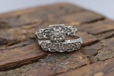 two wedding rings are sitting on top of a rock, one is white gold and the other is silver