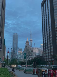 a city street with tall buildings in the background