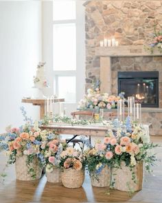 a table with flowers and candles on it in front of a fire place filled with candles