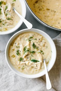 two white bowls filled with soup next to a pot