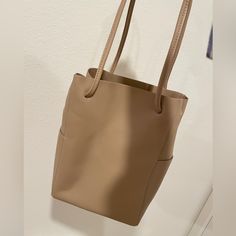 Beige Cream Color. With Two Side Pockets. 9” L X 5 1/4” W X 12 3/4” H Classic Beige Bucket Bag For On-the-go, Beige Soft Leather Bag For On-the-go, Large Capacity Beige Hobo Bag For On-the-go, Versatile Beige Bucket Bag, Cream Bucket Bag With Removable Pouch For On-the-go, Versatile Beige Shoulder Bucket Bag, Versatile Beige Double Handle Bucket Bag, Beige Double Handle Satchel For On-the-go, Khaki Bucket Bag For Daily Use