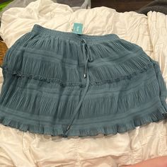 Cyan Ruffle Skirt. Never Been Worn And Still Has Tags. Has Drawstring In Front To Adjust Waist Blue Vacation Bottoms With Ruffle Hem, Blue Ruffle Hem Bottoms For Vacation, Vacation Blue Bottoms With Ruffle Hem, Casual Pleated Mini Skirt For Beach, Casual Pleated Skirt Bottoms For Brunch, Blue Ruffle Hem Skirt For Vacation, Flowy Casual Mini Skirt, Casual Pleated Tiered Skirt Bottoms, Casual Flowy Bottoms For Brunch