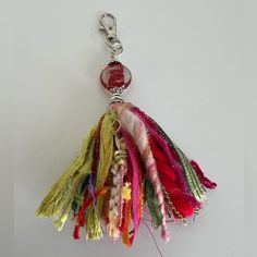 a multicolored keychain hanging from a metal hook on a white surface