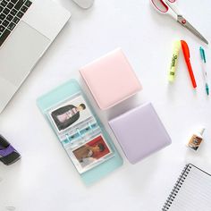 an open laptop computer sitting on top of a white desk next to a notebook and pen