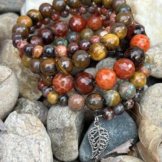 Earth tones of green, brown, red and orange define this 5 wrap boho bracelet.Genuine semi-precious stones featuring Tiger's Eye, Jasper, and Crackle Agate make up this done-for-you stack. 4mm round jasper 8mm Tiger's Eye 10mm faceted Crackle Agate one size fits most - best for small to medium wrists Handmade in Lincoln, Nebraska Artisan Hand Wrapped Wrap Bracelet With Round Beads, Carnelian Beaded Bracelets With Natural Stones For Meditation, Handmade Wrap Bracelet With Round Beads For Healing, Bohemian Jasper Round Bead Bracelets, Brown Gemstone Beads Wrap Bracelet Gift, Spiritual Multi-strand Hand Wrapped Bracelets, Bohemian Brown Beaded Bracelets With Gemstones, Multicolor Hand-strung Spiritual Wrap Bracelet, Brown Natural Stone Wrap Bracelet Gift