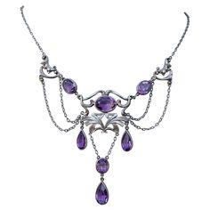 THIS IS A RARE MUSEUM QUALITY ART NOUVEAU - BELLE EPOQUE FESTOON NECKLACE WITH THE MOST GORGEOUS NATURAL OVAL AND PEAR SHAPE AMETHYST GEMS SET IN A GORGEOUS SCROLL ACANTHUS LEAF MOTIF SETTING IN AN OPEN WORK FESTOON SWAG DESIGN IN STERLING SILVER DATING TO CIRCA 1890-1900. It is very rare to find antique Art Nouveau Festoon necklaces in Sterling Silver. The combination of the gorgeous silver work with the purple amethysts is absolutely magnificent. The art nouveau scrolling acanthus leaf design Victorian Pendant Necklace, Motifs Art Nouveau, Swag Design, Festoon Necklace, Art Nouveau Necklaces, Art Nouveau Silver, Art Nouveau Pendant, Autumn Necklace, Victorian Pendants