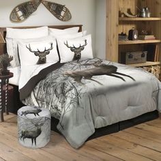 a bed with deer head on it in a room next to a chair and table