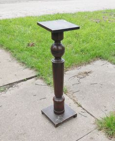 a wooden table sitting on top of a sidewalk next to a grass covered park area