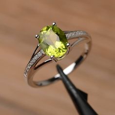 It is a natural peridot ring. The main stone is 7mm*9mm oval cut, weight about 1.99 carats.The basic metal is sterling silver and plated with rhodium.To change the metal to a solid gold (white/rose) or platinum is also available, please ask for a quotation if you want.You can also go to my shop Home for more elegant rings: https://www.etsy.com/shop/godjewelry?ref=hdr_shop_menuMore rings:https://www.etsy.com/shop/godjewelry?ref=l2-shop-header-avatarCustomization is always welcome and please feel Rainbow Topaz Ring, Peridot Engagement Rings, August Birthstone Ring, June Birthstone Ring, August Birthstone, Peridot Ring, Engagement Rings Oval, Ring Oval, White Gold Engagement