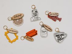 six keychains with different designs and sayings are shown in the shape of people's heads