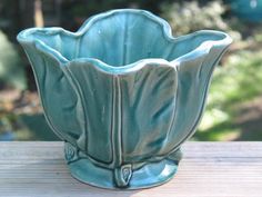 a blue vase sitting on top of a wooden table