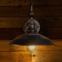 a light that is on the side of a wooden wall next to a wood paneled wall