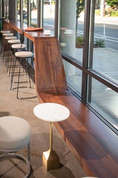 a row of white stools sitting next to a window